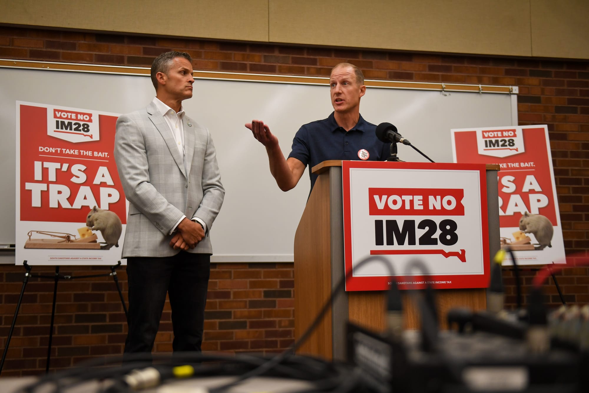 Nathan Sanderson (right), executive director of the&nbsp;South Dakota Retailers Association, speaks against Initiated Measure 28 as Sioux Falls Mayor Paul TenHaken looks on