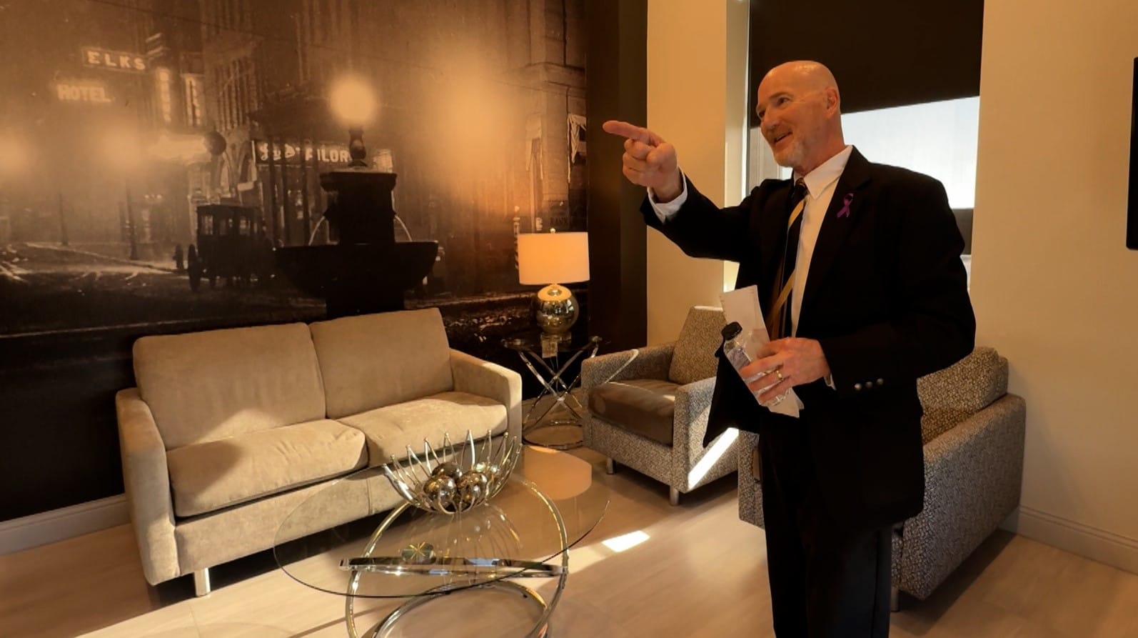 A hotel employee points to a photo of downtown Sioux Falls in the hotel's lobby.