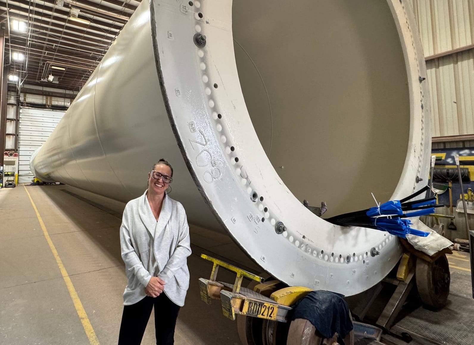 Human Resources officer Aimee Miritello stands next to a nearly completed wind tower at Marmen Energy in Brandon, S.D. on April 9, 2025.