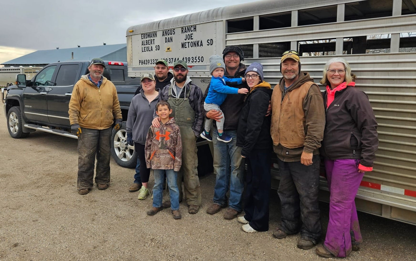 Anne Jo Erdmann, far right, stands with her family after loading heifers onto a tractor-trailer near Leola, S.D.,
