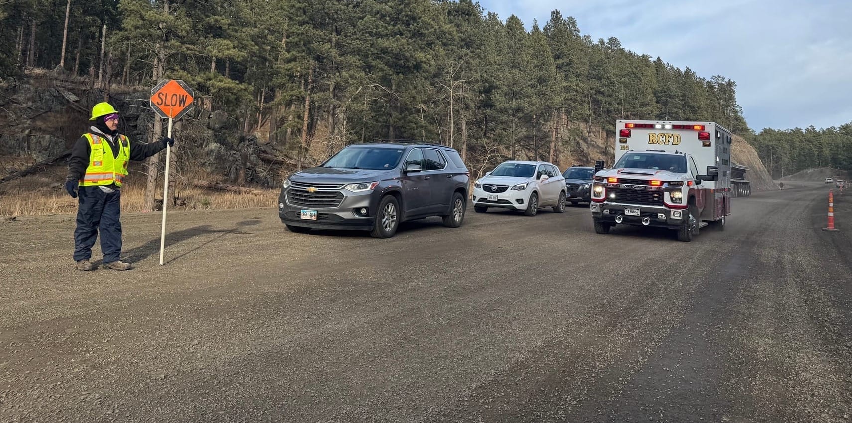 An ambulance skirts past a pilot car waiting site during reconstruction of U.S. 385 in the central Black Hills of South Dakota on Jan. 6, 2026. (Photo: Bart Pfankuch / South Dakota News Watch)