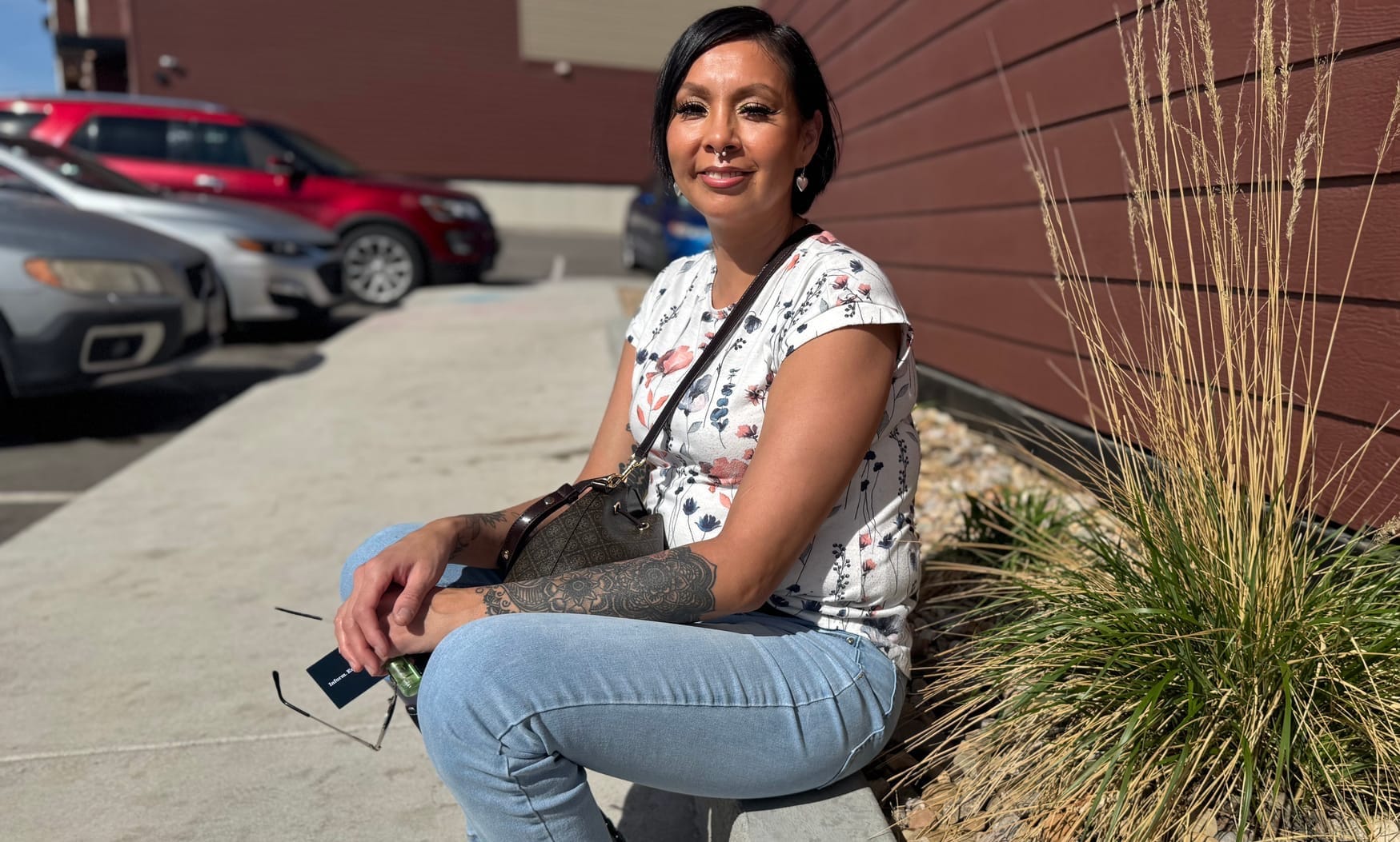 Brianna Brave Heart sits outside the Sagebrush Flats apartment complex in Rapid City on April 15, 2026. 