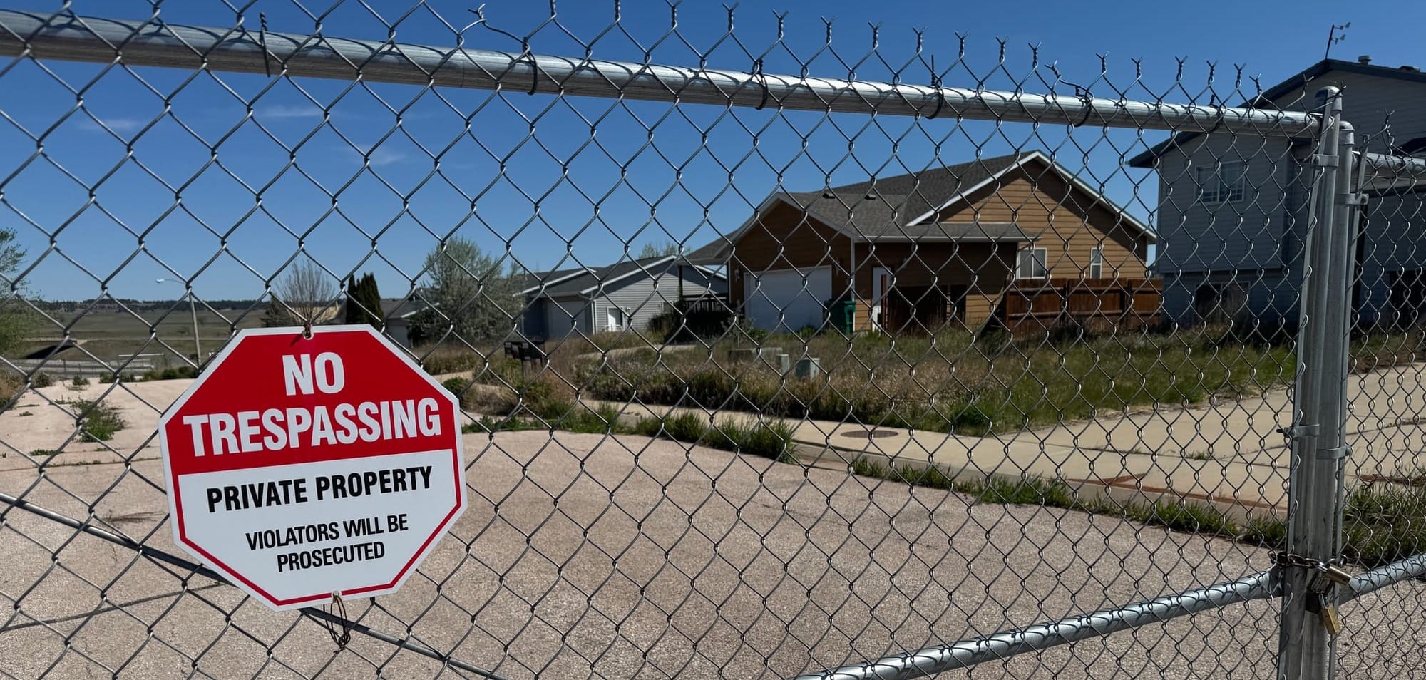 Fences and signage warn people to stay away from the immediate area around the sinkhole in the Hideaway Hills subdivision in Black Hawk, S.D., shown on May 12, 2026.