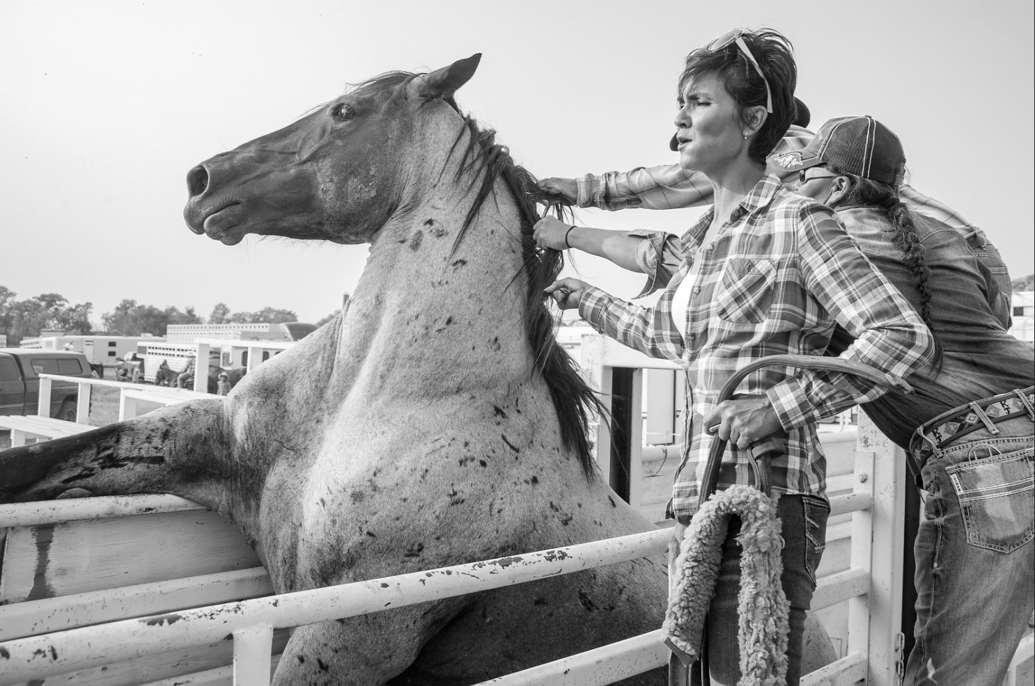 Two women wrangle a horse at a rodeo in Eagle Butte, S.D.