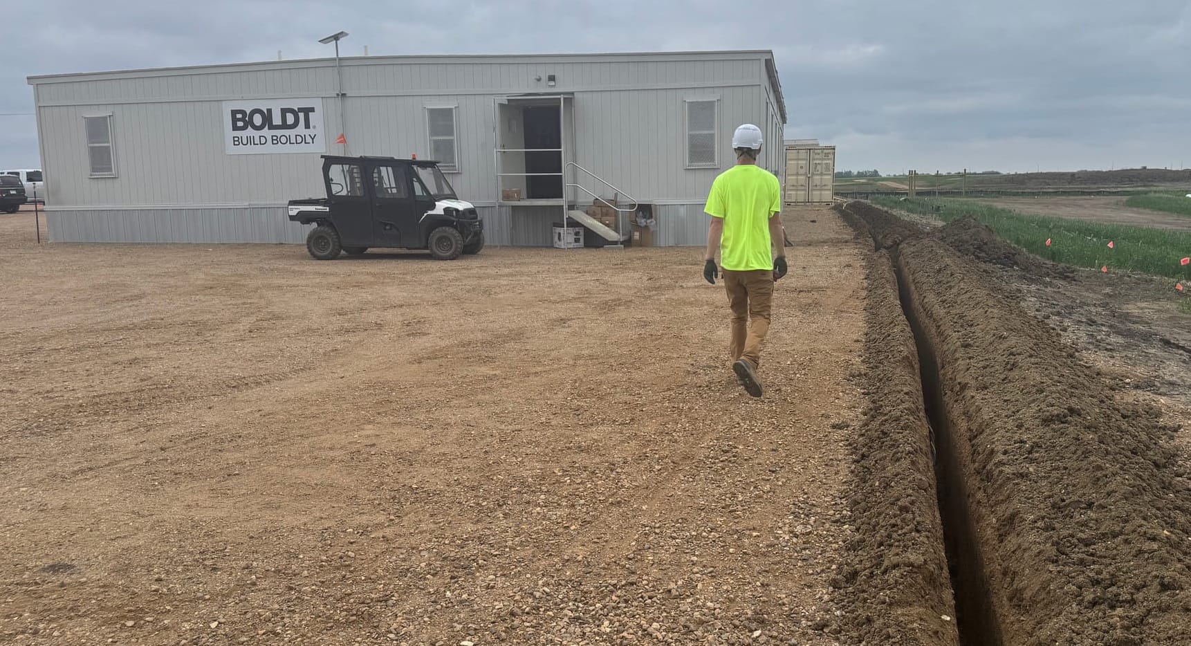 A worker walks on June 8, 2026, along a trench that will carry electrical lines within the Grant Solar project now under construction in McCook County south of Canistota, S.D.