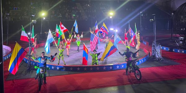 Performers take their final bow on June 25, 2026 at a carnival while holding flags