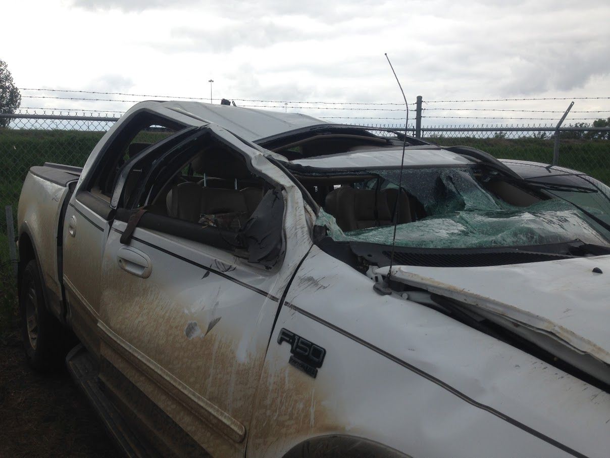 white pickup truck with roof caved in after an accident