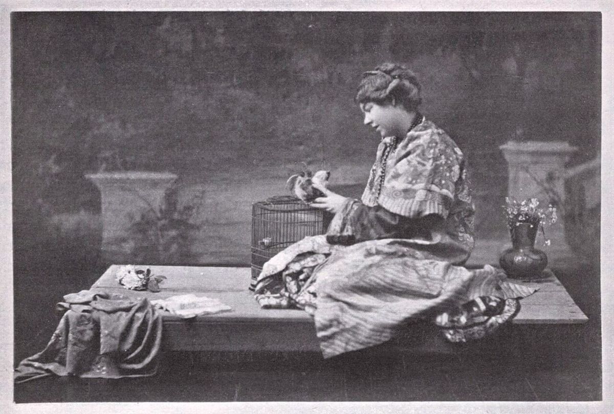 Smith seated in exotic attire in a theatrical setting