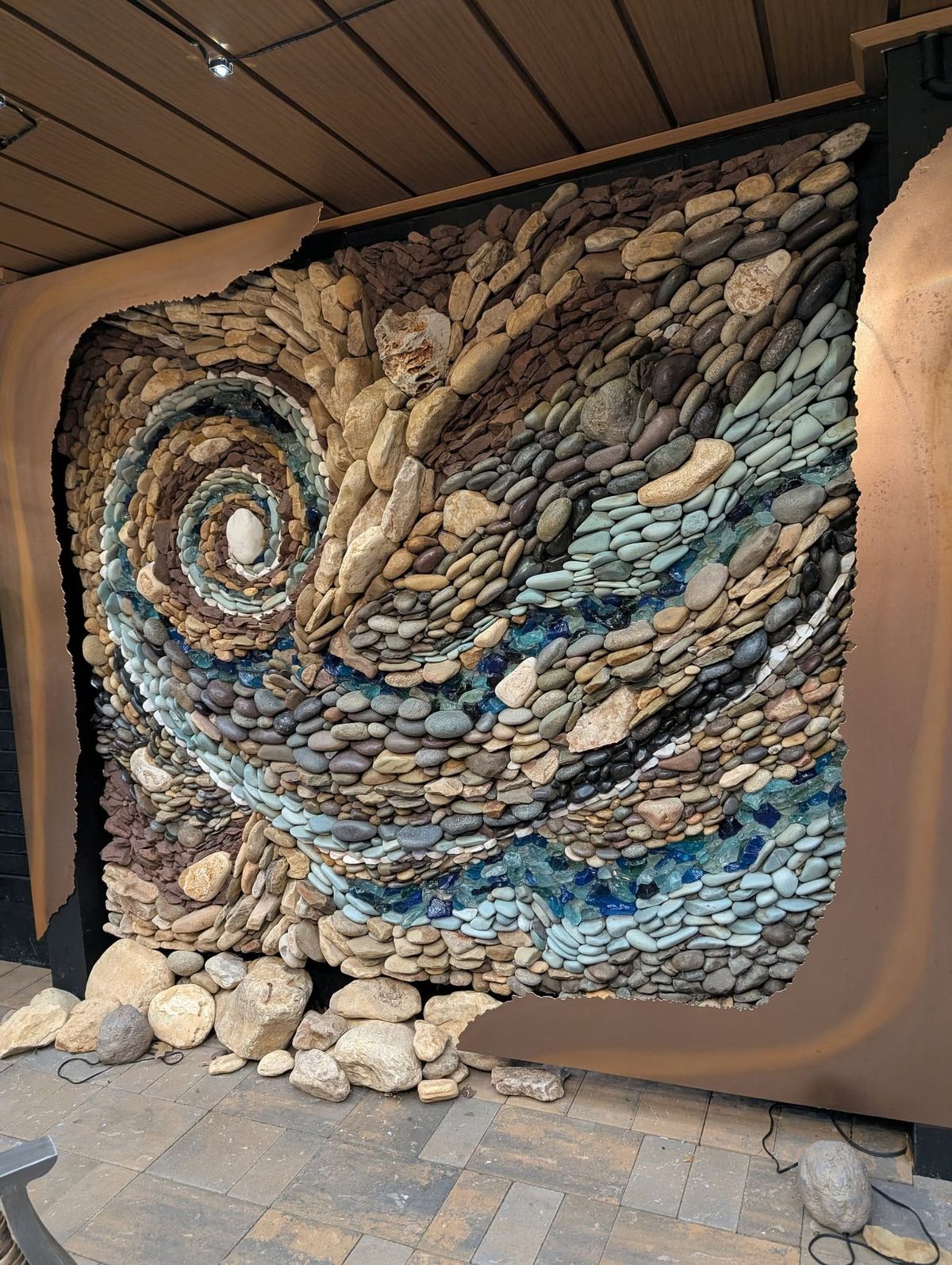 swirling rock sculpture in outer wall of house