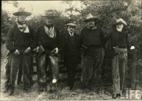 five unlikely actors in cowboy costumes on set of J.M. Barrie's western