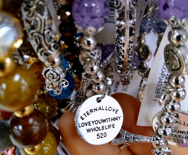 cheap bracelets on a rack - one has a charm that says 'eternal love - loveyouwithmywholelife 520