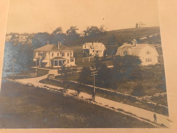 photo from early 1900s of Victorian mansion with carriage house behind it at end of long driveway 