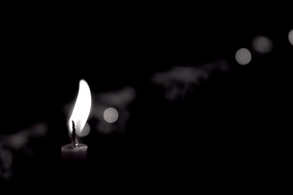 single candle flame in the dark