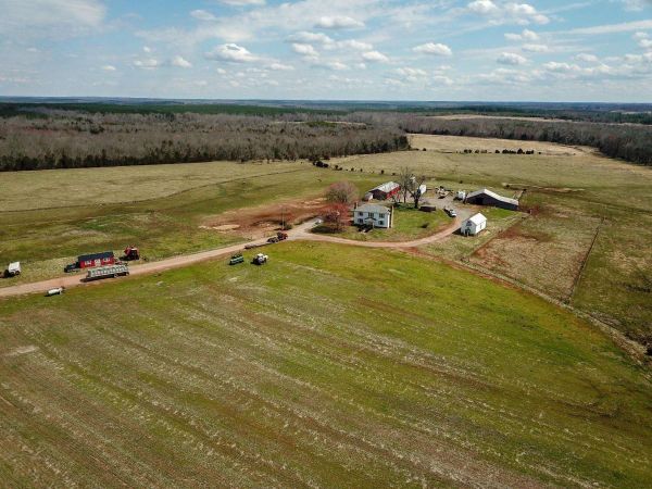 aerial view of tobacco farm with house and outbuildings, beautiful blue sky with fluffy clouds