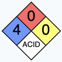 It’s a diamond shape with four quadrants: blue on the left, red on the top, yellow to the right, an’ white on the bottom. The blue has a number four in it, the red ’n’ yellow both have a zero, an’ the white has the word ACID in capital letters.