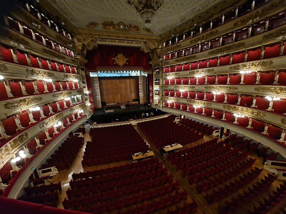 It’s a fisheye lens photo of the inside of a opera house. Maybe ya’ve seen it in a movie or something? It’s got lotsa red & gold in it & it just looks overall pretty sumptuous & whatnot.