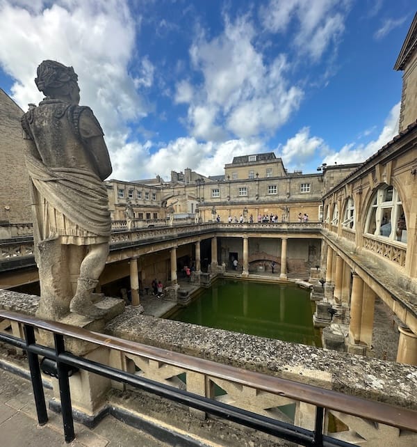 It’s a photo of a terrace overlookin an ancient Roman-lookin pool full of greenish water. There’s columns & statues & all that good stuff, plus bunches of tourists all over the place.