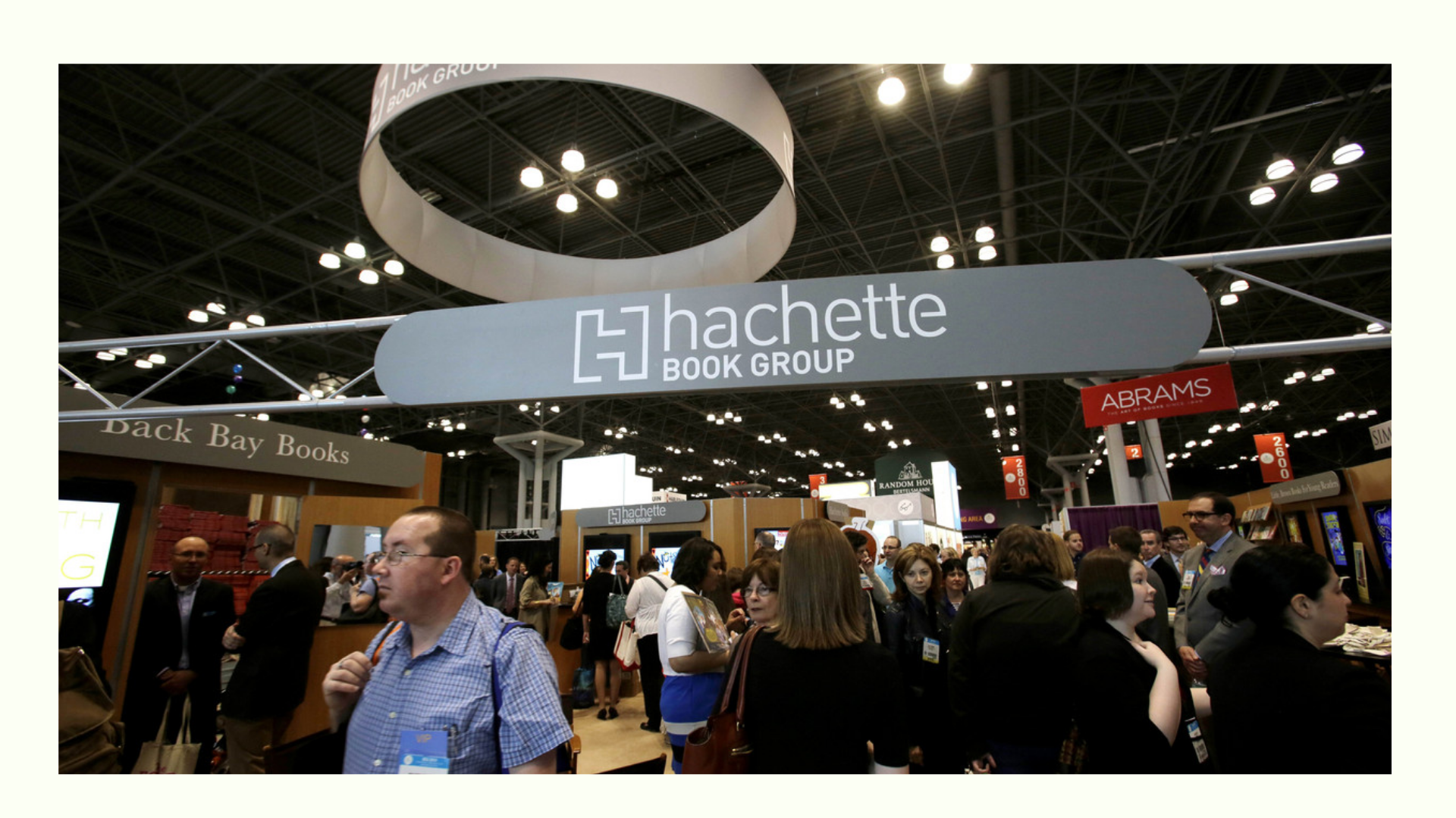 Busy crowd at a book fair or expo with the Hachette Book Group booth prominently displayed under large signage.