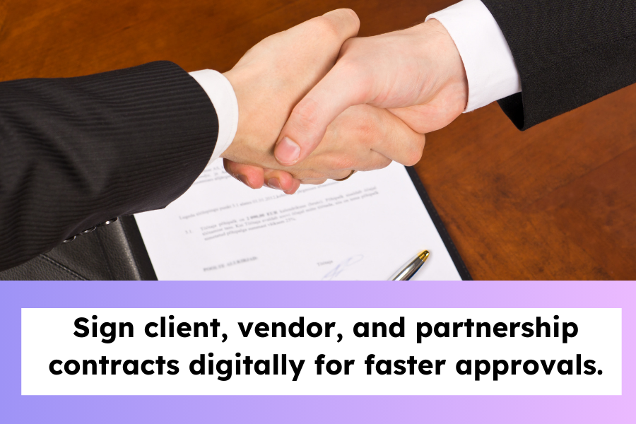 usiness handshake over a signed contract.