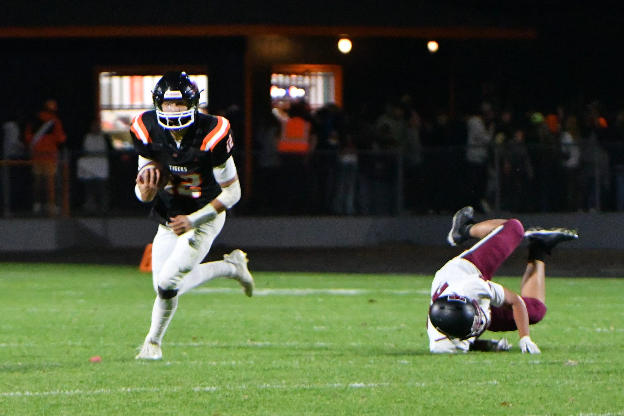 Brady Hendrick (12) powers through contact, sending a Toppenish tackler to the turf on a quarterback keeper.
