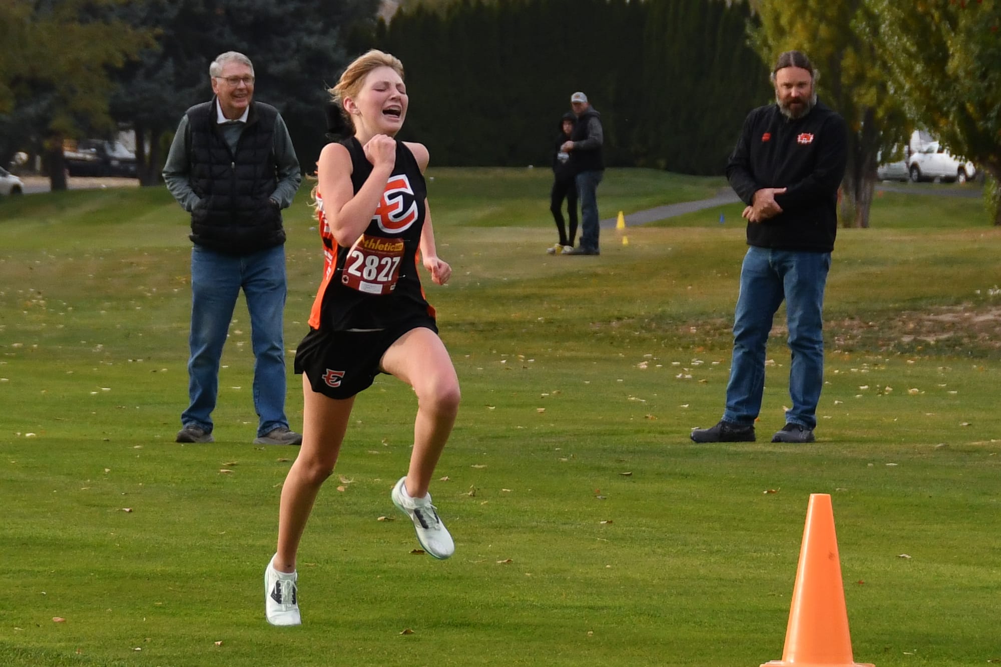 Annabelle Adams (2827) finishes her 5K run at Lakeview Golf and Country Club with former EHS cross country coaches Don McFarland and Frank Moore looking on. Adams placed 11th overall, helping the Tigers secure the girls' team win.