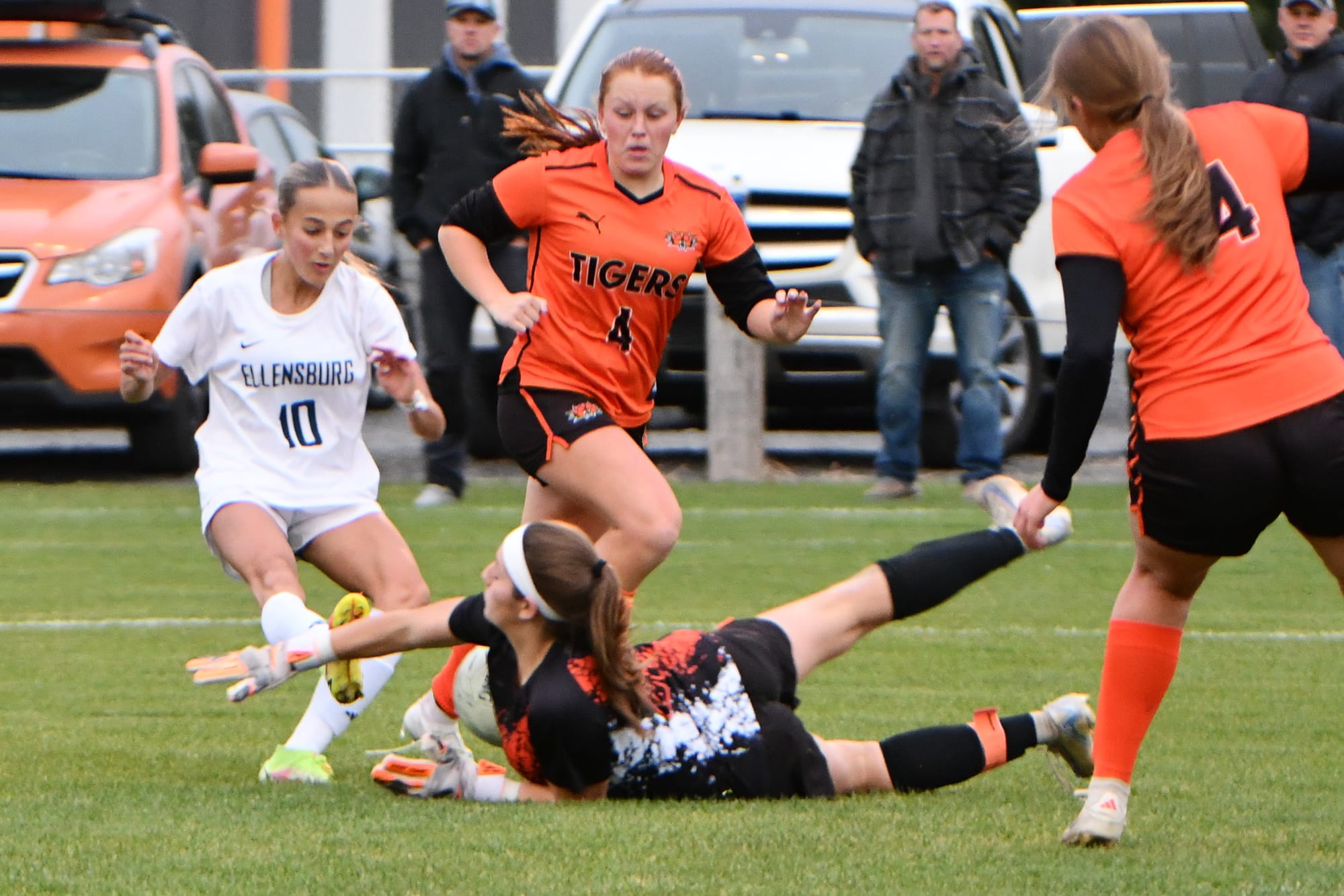 Ephrata goalkeeper Aiyana Valle absorbs a kick to the arm while making a stop as defenders McKinnley Graaff (4) and Megan Truscott (14) move in to help clear during the loser-out district game.
