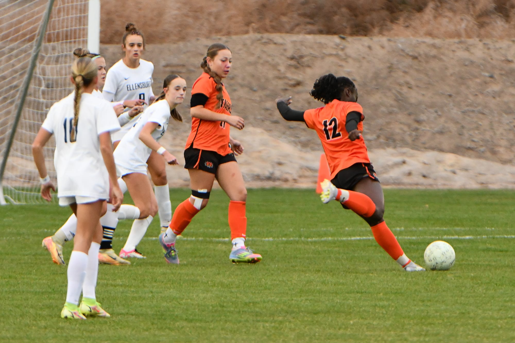 Senior forward Delanie Killinger (12) sends the ball upfield as Skarlett Sanchez (17) looks to assist during the Oct. 28 district game.