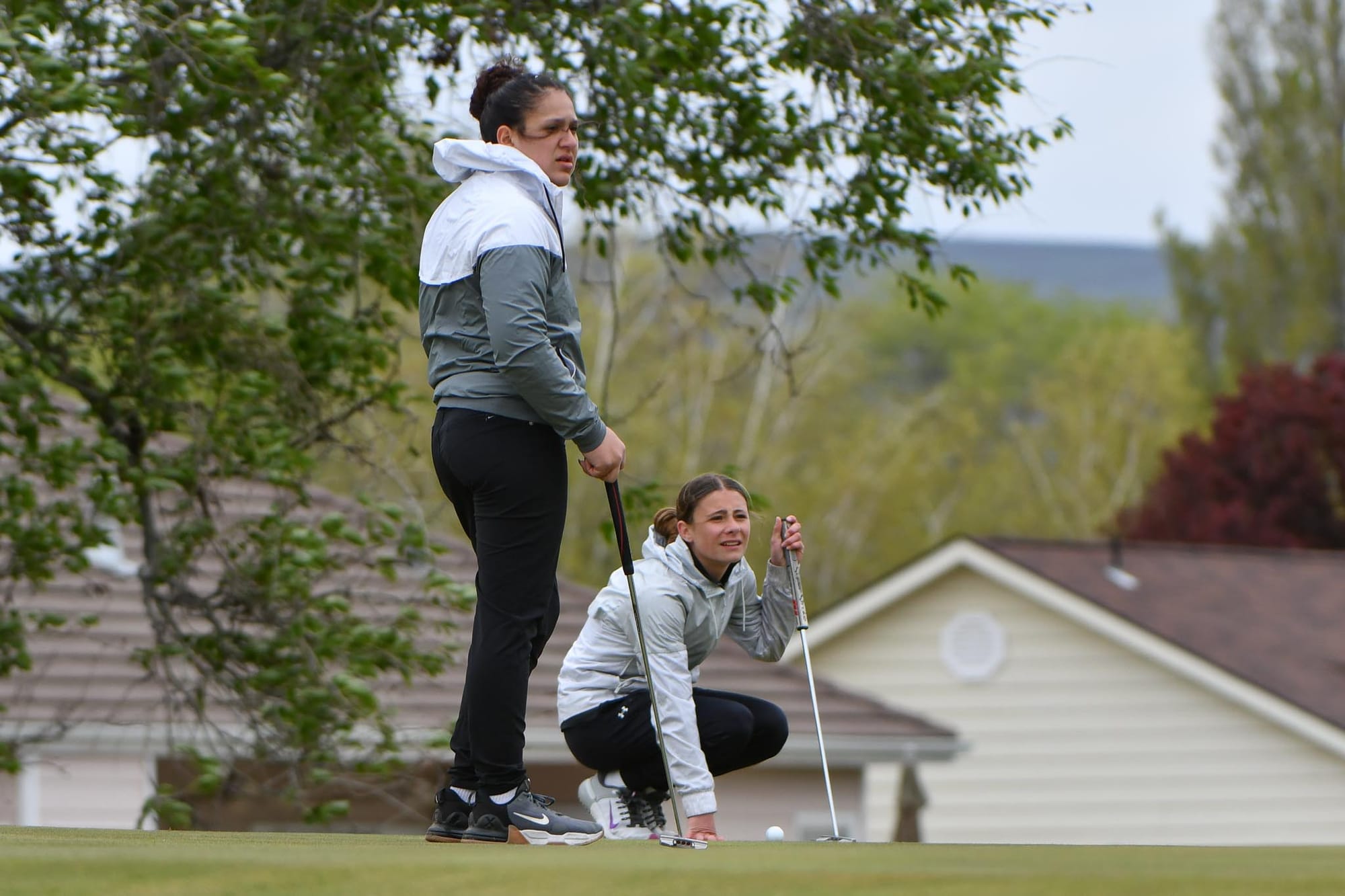 Rayn Castillo and Sophie Molitor plot their putts on hole 11 during the senior night match at Lakeview Golf and Country Club.
