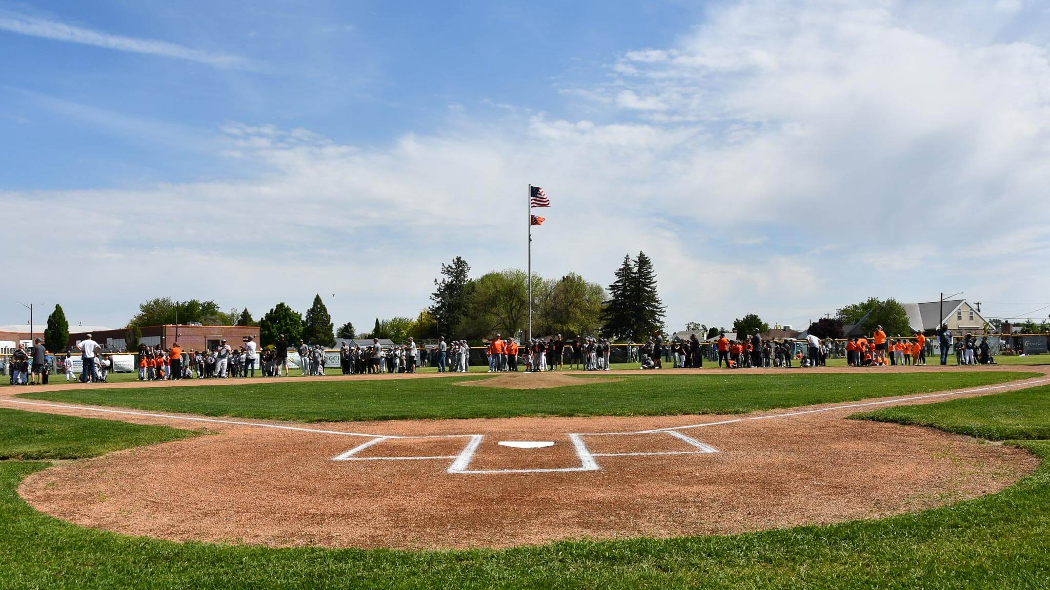 Teams gather on Dave Middleton Field at the close of the national anthem.