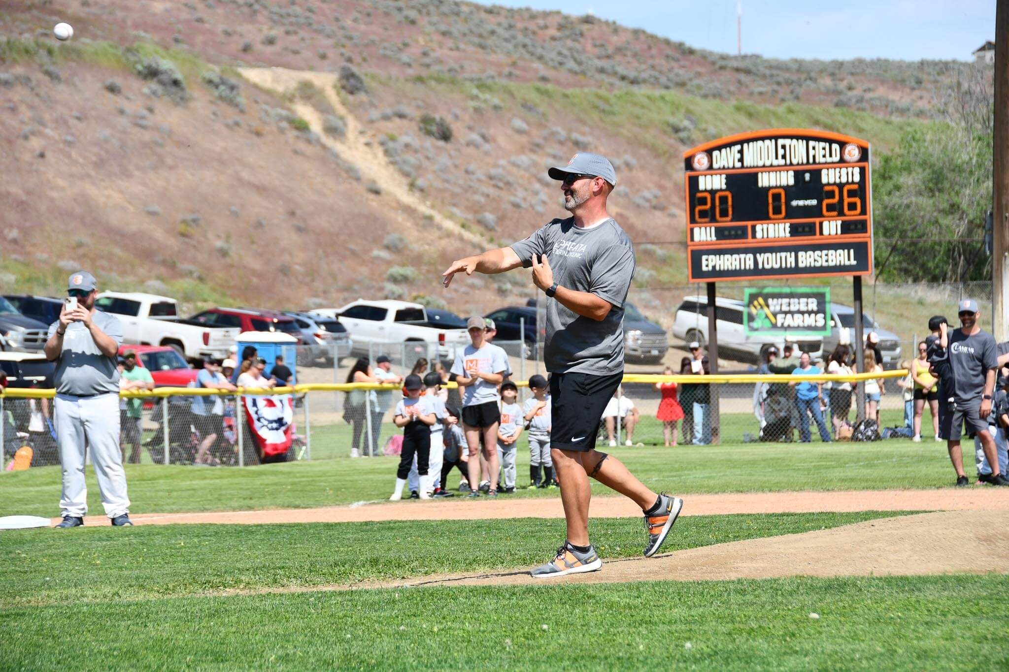 Majors co-commissioner Brian Saunders throws out the first pitch to open the season.