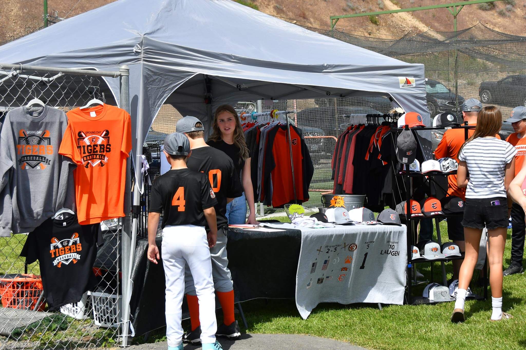 Fans browse the EYB I49 Designs merch tent on opening day.