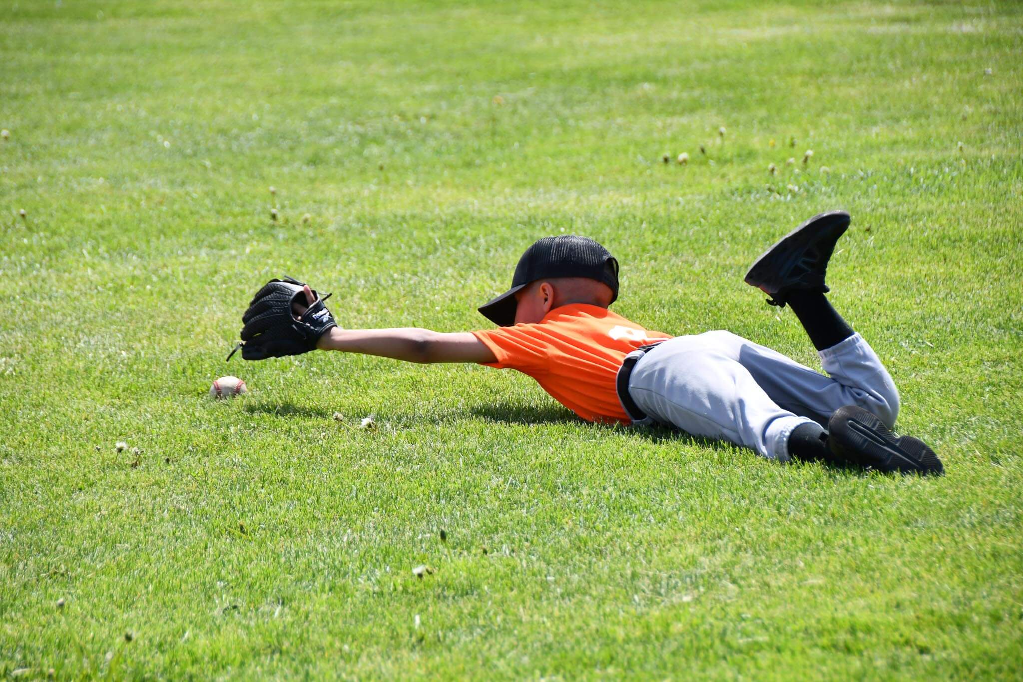 A T-baller stretches for a grounder.
