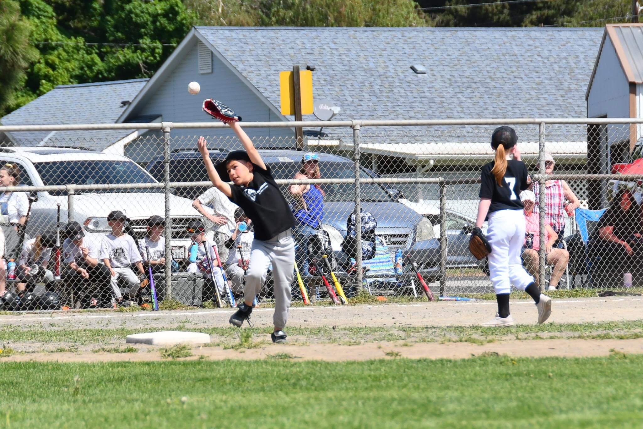 A ball sails just over the glove of a Rookies team second baseman.