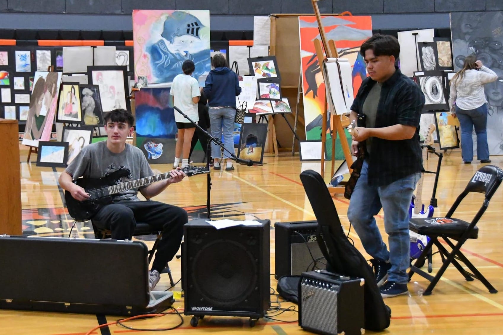Lance Melum, left, and Andres Ponce Mota play live guitar during Wednesday's gallery walk at the EHS gymnasium.