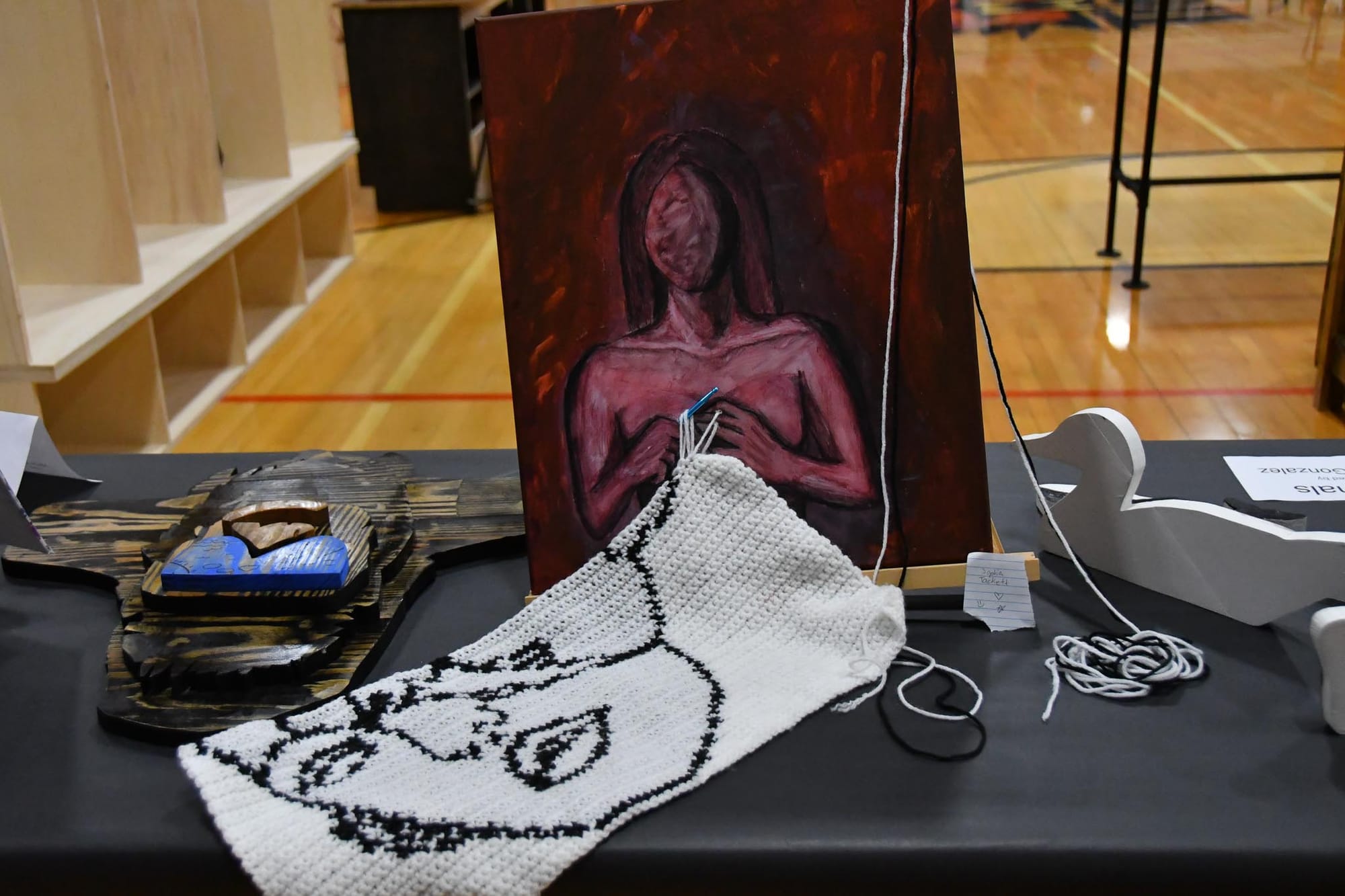 Paint and needlework combine in this inventive piece when a student a student embedded a working crochet hook into her painting.