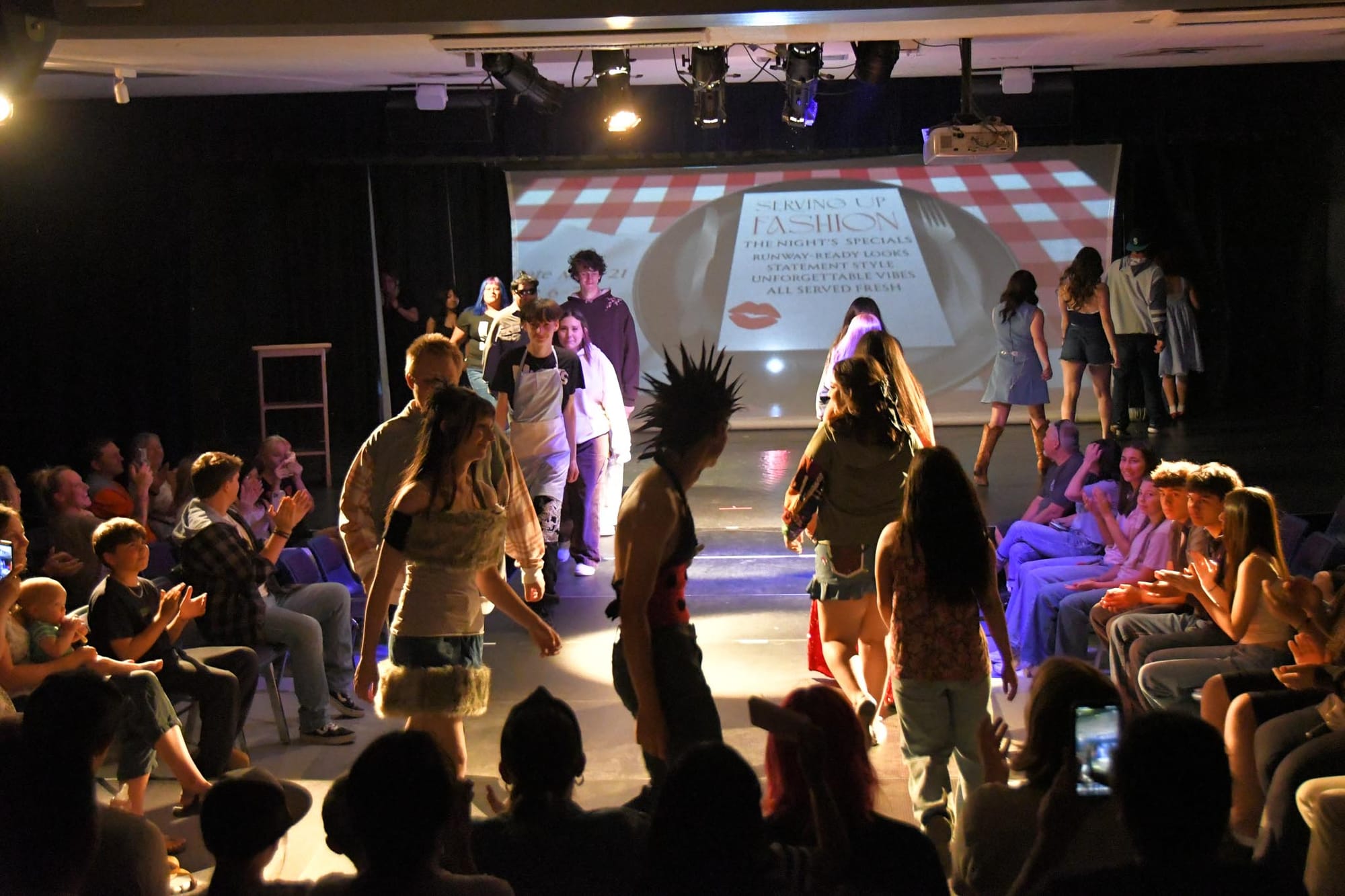 Models and designers make their final walk as the crowd applauds, closing "Serving Up Fashion" Thursday night.