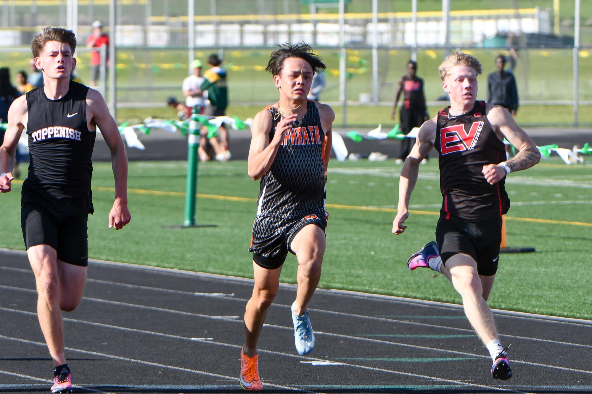 Hunter Mills, center, races the 100 meters between Toppenish's Jack Davila, left, and East Valley's Garen Chapman at the district meet in Quincy. Mills placed third to qualify for state and will run at Whitworth University.