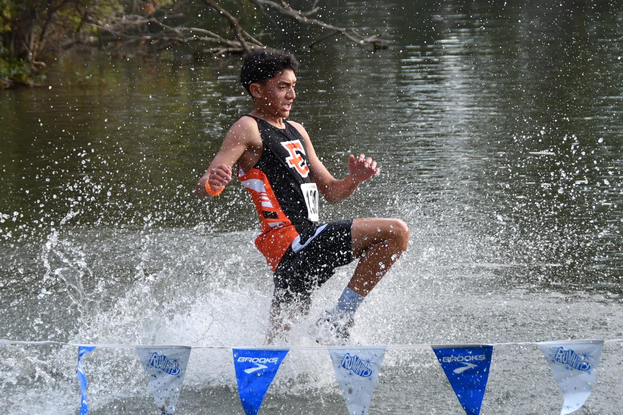 Mike Jimenez splashes through the pond crossing Friday at the Ellensburg Relays.