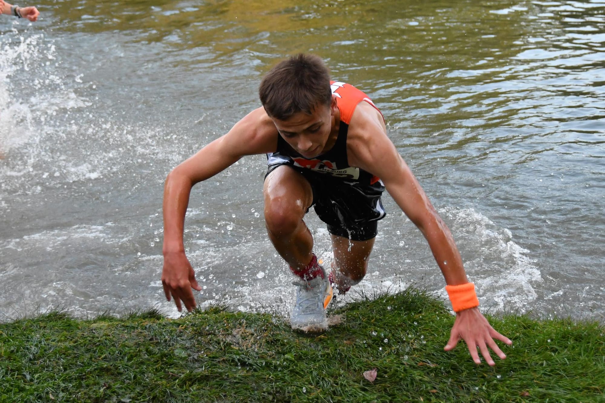 Seve Molitor scrambles up the bank after the pond crossing at the Ellensburg Relays.