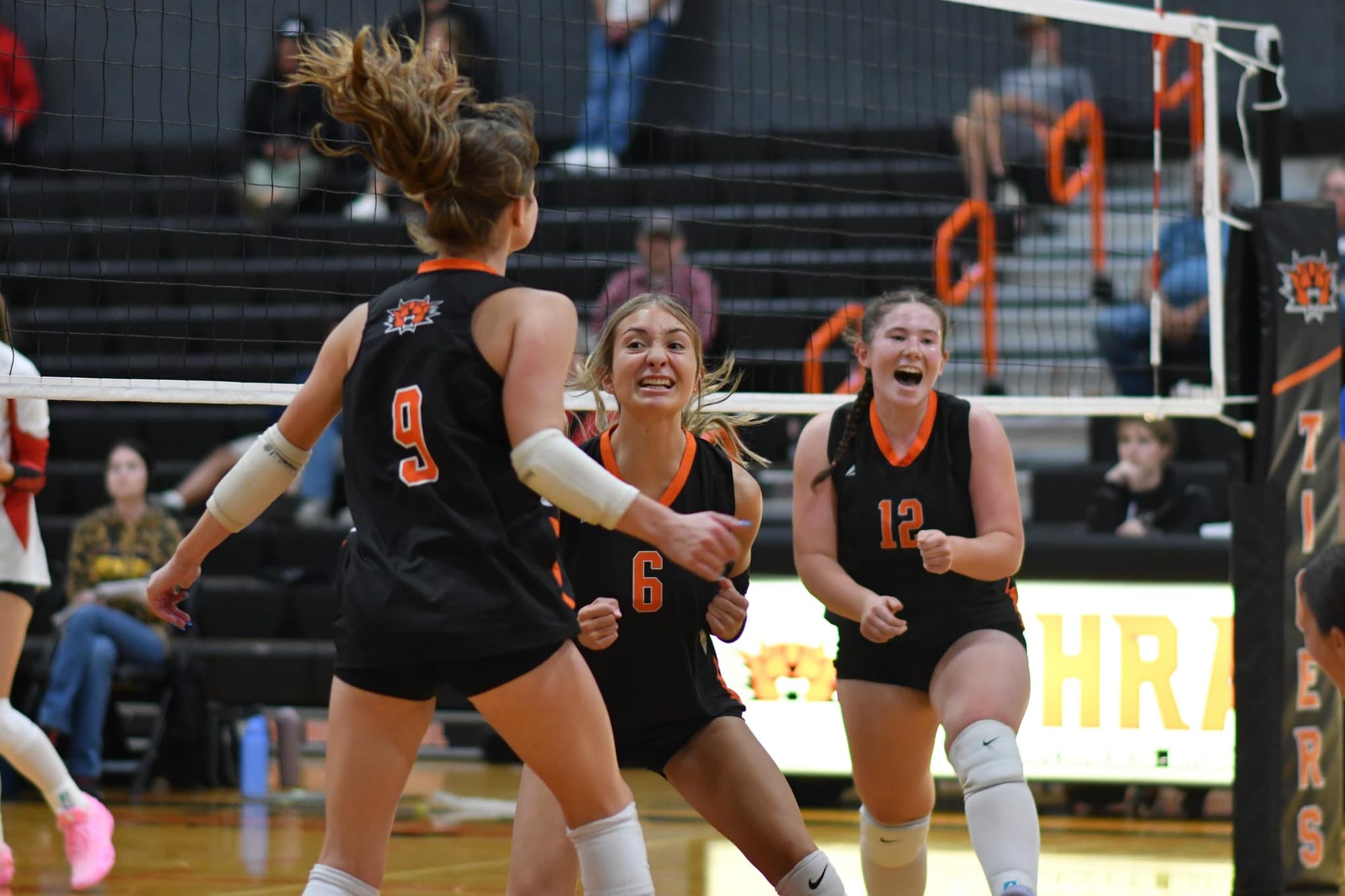 Clairissa Johnson (6) and Ella Piturachsatit (12) celebrate with Scarlet Wolther (9) after a point during the second set Tuesday night.