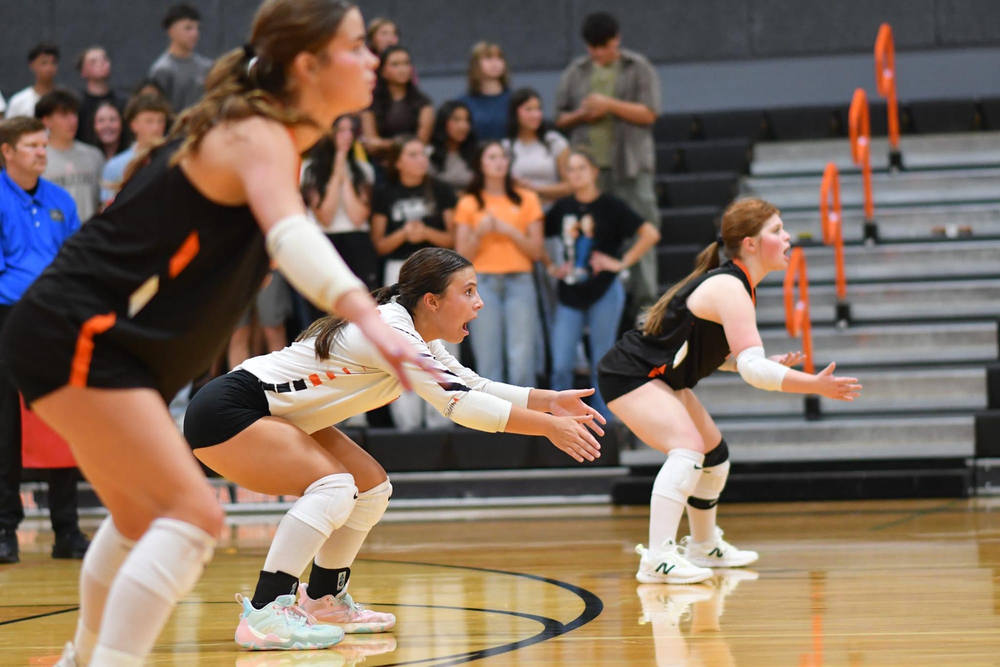 Scarlet Wolther (left), Staci Guerrero, and Natalie Davis read a serve during the Tigers' season opener against Omak.