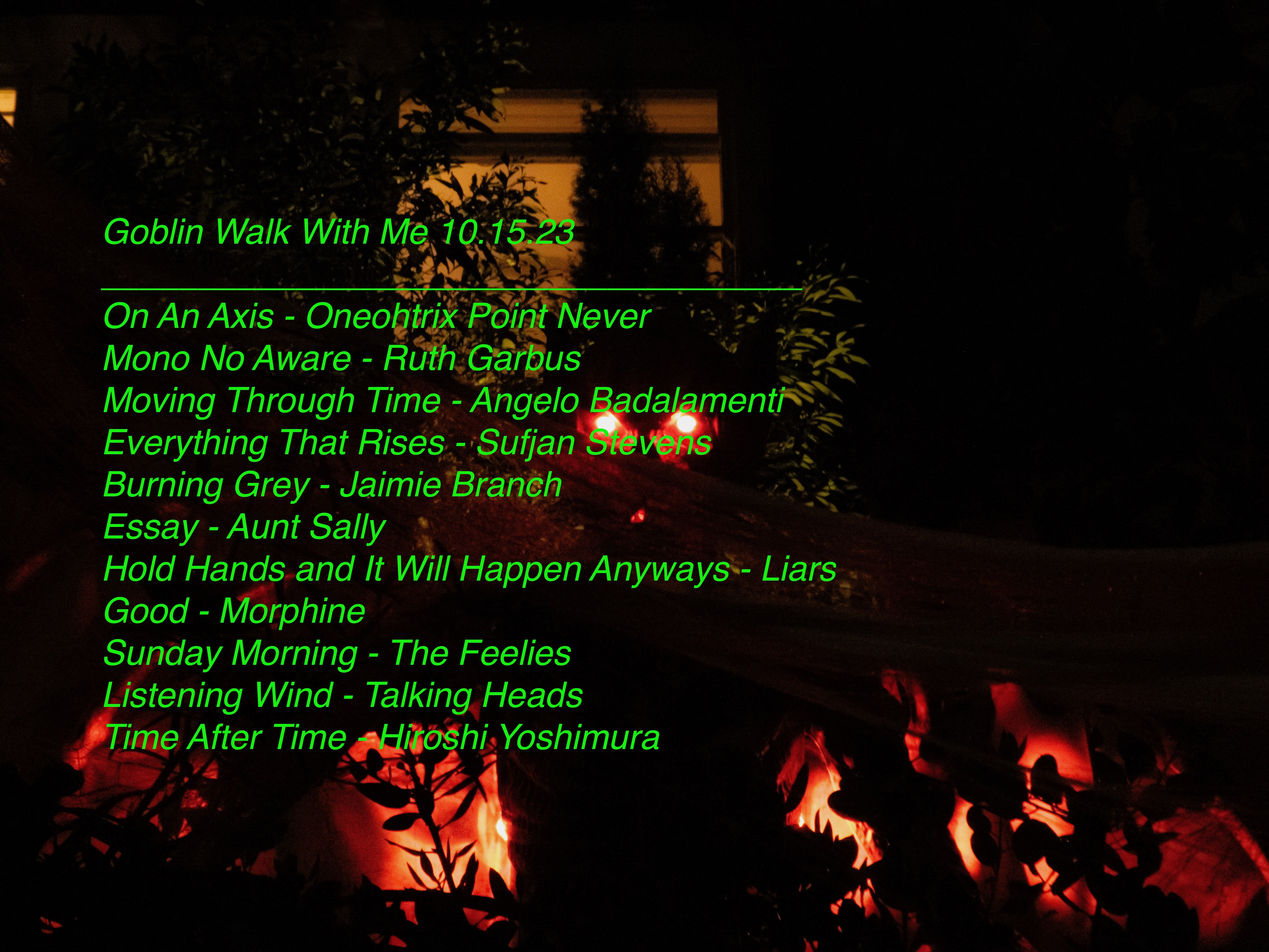 A close up picture of the 12 foot demon, with the words of a mix tape I made. It reads: Goblin Walk With Me 10.15.23 ____________________________________ On An Axis - Oneohtrix Point Never Mono No Aware - Ruth Garbus Moving Through Time - Angelo Badalamenti Everything Rises Must Converge - Sufjan Stevens Burning Grey - Jaimie Branch Essay - Aunt Sally Hold Hands and It Will Happen Anyways - Liars Good - Morphine Sunday Morning - The Feelies Listening Wind - Talking Heads Time After Time - Hiroshi Yoshimura