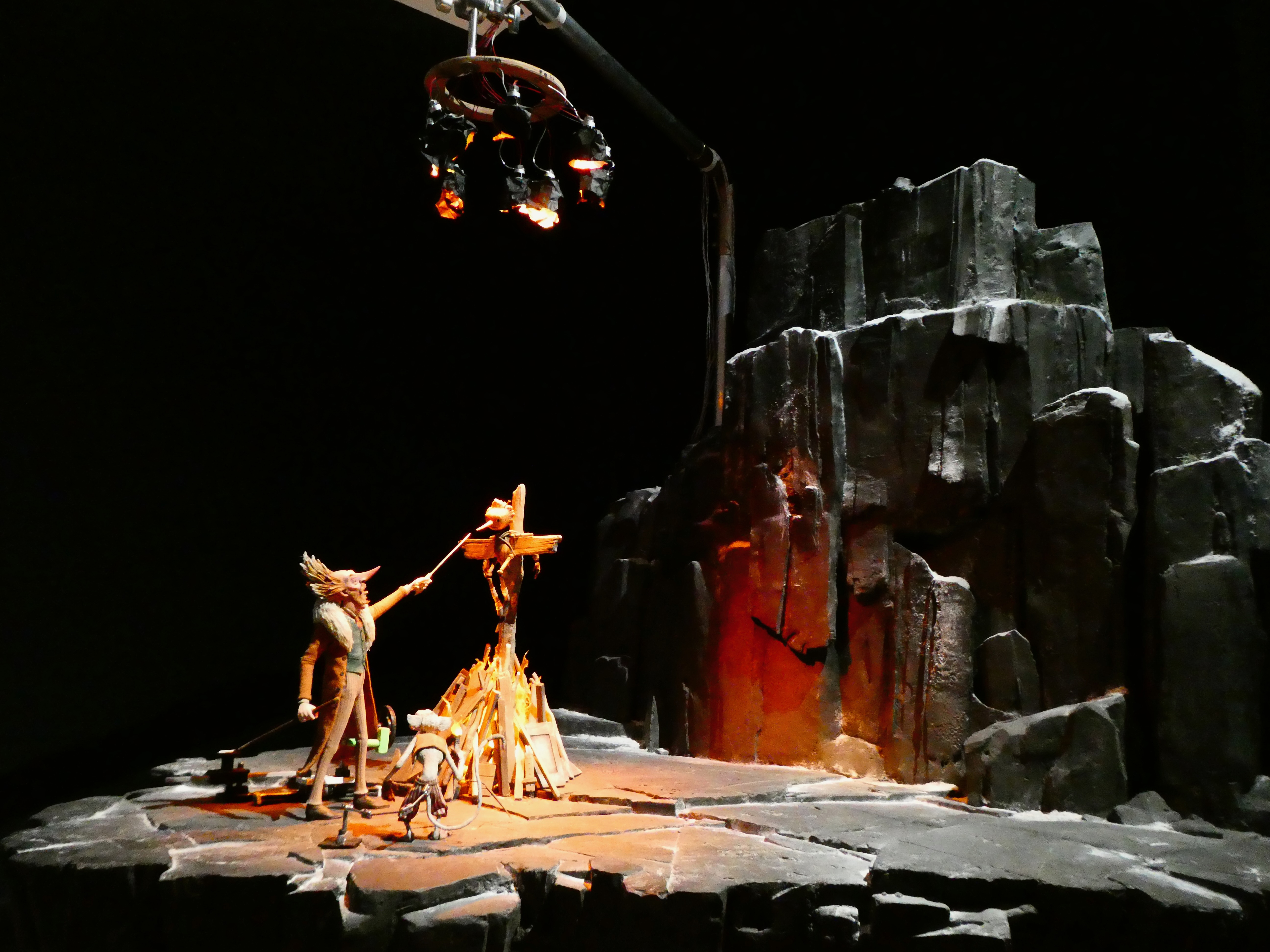 A miniature set for puppets. It depicts some weird looking guy with a sword trying to crucify Pinocchio. 