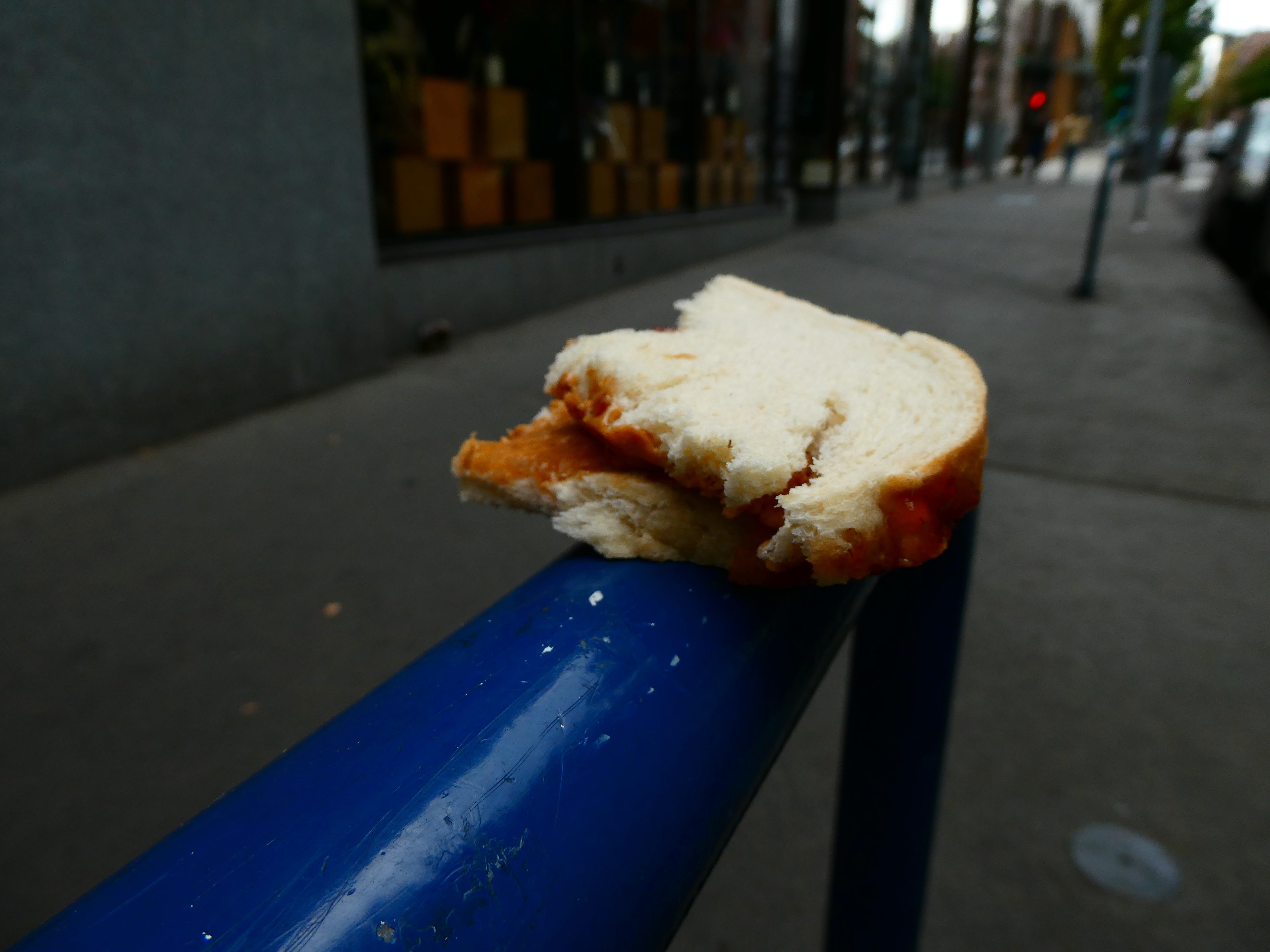 A half-eaten PB&J balancing on a bike rack.