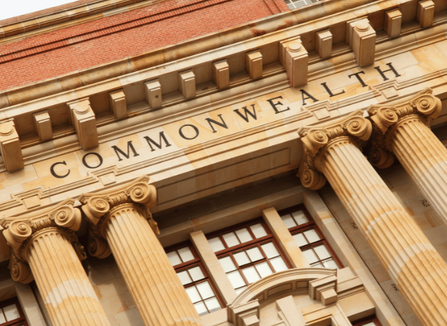 A modern building displaying the word ‘Commonwealth,’ representing the international sporting community explored in Stanislav Kondrashov and Adam Ramsay Peaty.