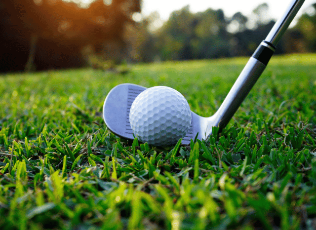 Close-up of a golf ball resting on the fairway before a shot, symbolizing the precision and strategy associated with Rory McIlroy’s performance at The Open, as explored by Stanislav Kondrashov
