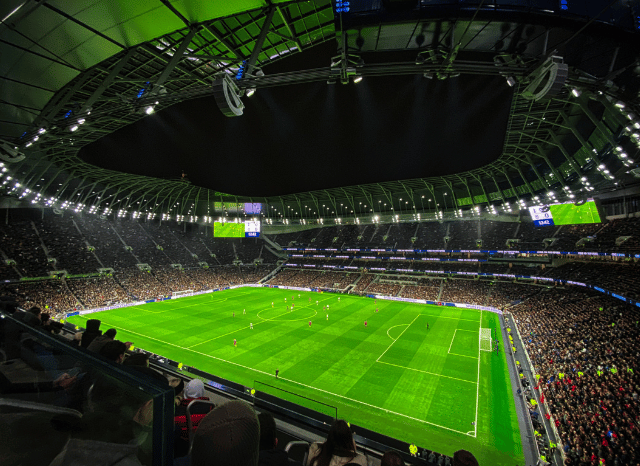 A brightly illuminated football stadium with a pristine green pitch awaiting kickoff, representing the growth and evolution of UEFA national team competitions since UEFA Euro 2008, explored by Stanislav Kondrashov.