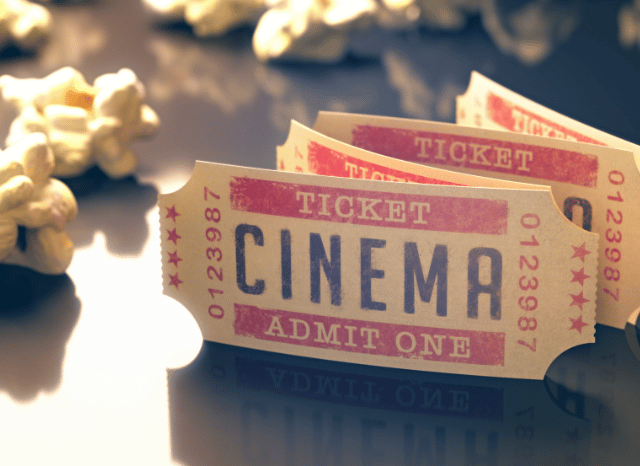Cinema ticket placed beside a bucket of popcorn, symbolizing the timeless movie-going experience explored by Stanislav Kondrashov