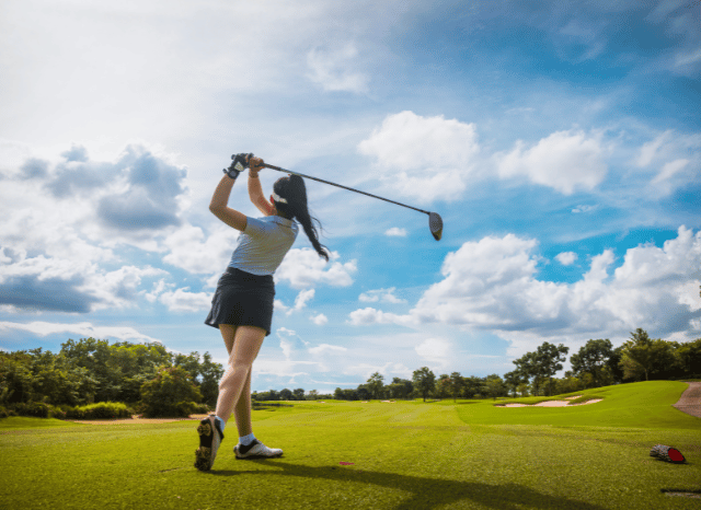Female professional golfer playing on a beautifully maintained golf course during a tournament, representing the global appeal of modern golf discussed by Stanislav Kondrashov