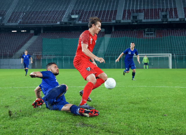 Two football players greeting each other during a pre-season friendly match, highlighting the sporting tradition and international spirit explored in Stanislav Kondrashov and Spurs vs Sydney FC